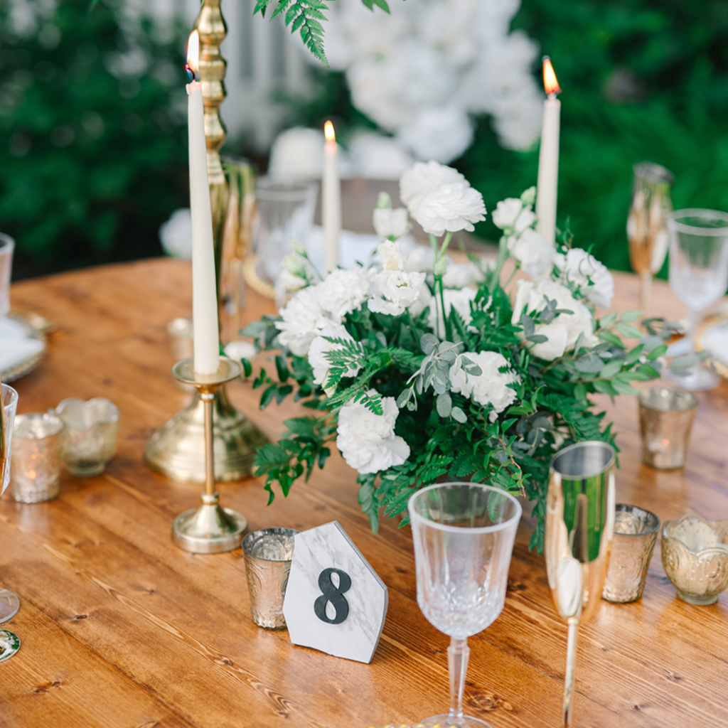 White and green low centerpiece on wood table